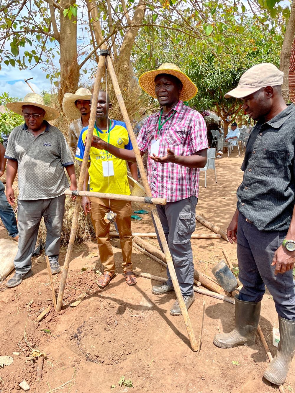 Man uses a-frame to map contour of site.